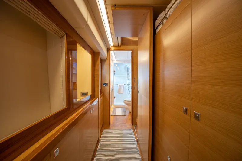 Mystic Soul Yacht Photos Pics Luxurious wooden hallway on a 2019 Horizon PC52 yacht, leading to a modern bathroom.