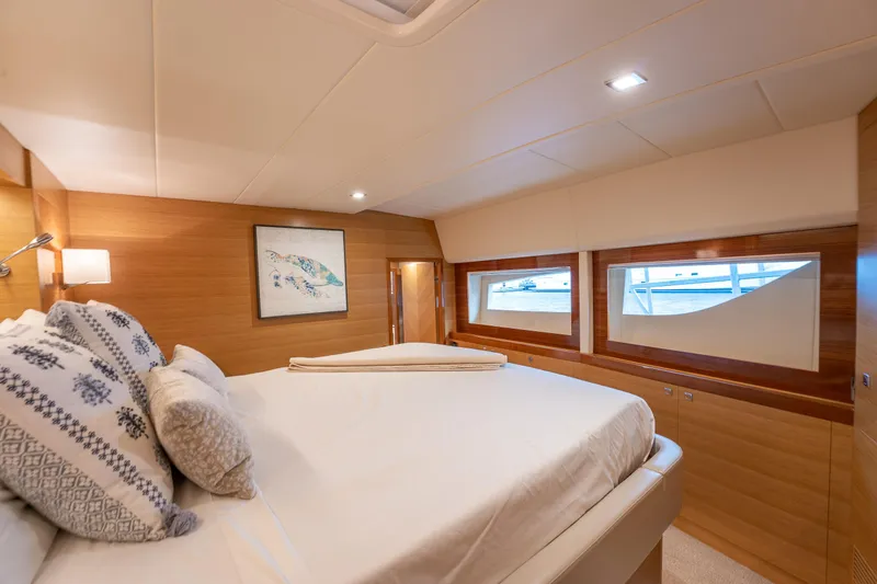 Mystic Soul Yacht Photos Pics Luxurious 2019 Horizon PC52 yacht bedroom with elegant wood paneling and large windows.