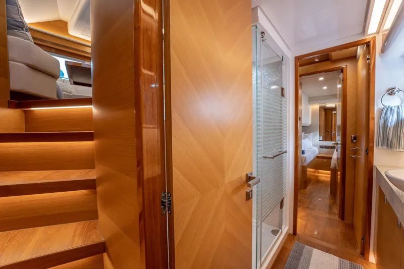 Mystic Soul Yacht Photos Pics Luxurious interior of 2019 Horizon PC52 yacht featuring wooden stairs, bathroom, and bedroom.