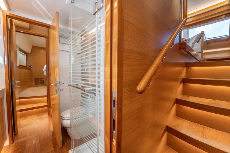 Mystic Soul Yacht Photos Pics Luxurious 2019 Horizon PC52 yacht interior with wooden stairs, bathroom, and bedroom.