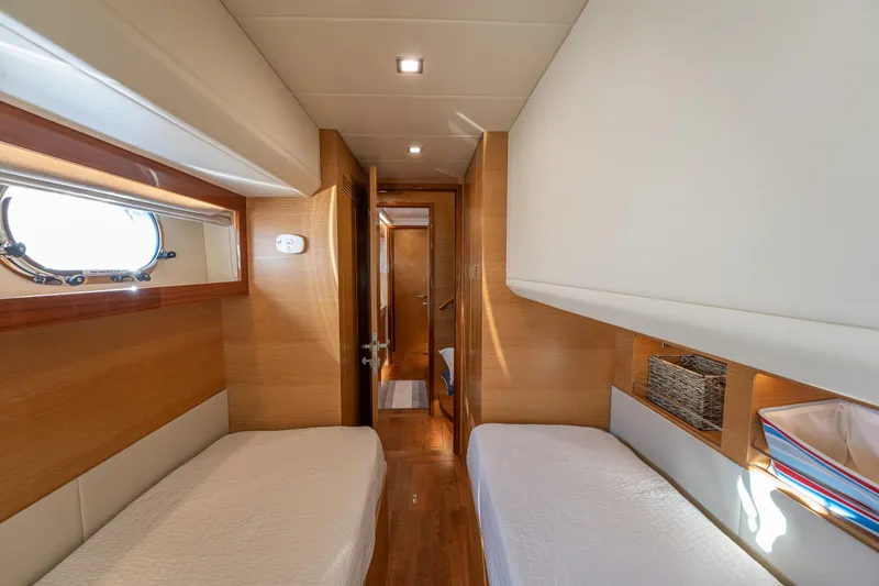 Mystic Soul Yacht Photos Pics Interior of 2019 Horizon PC52 yacht cabin with twin beds and wooden accents.