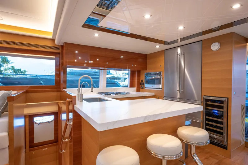 Mystic Soul Yacht Photos Pics Luxurious yacht kitchen interior with modern appliances, marble countertops, and wooden cabinetry. Horizon PC52, 2019.