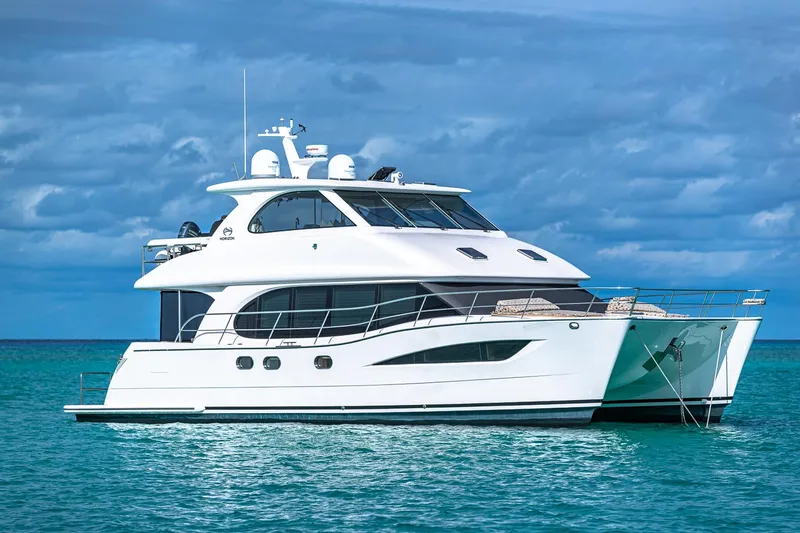 Mystic Soul Yacht Photos Pics Luxury Horizon PC52 yacht on turquoise water under a cloudy sky, 2019 model.
