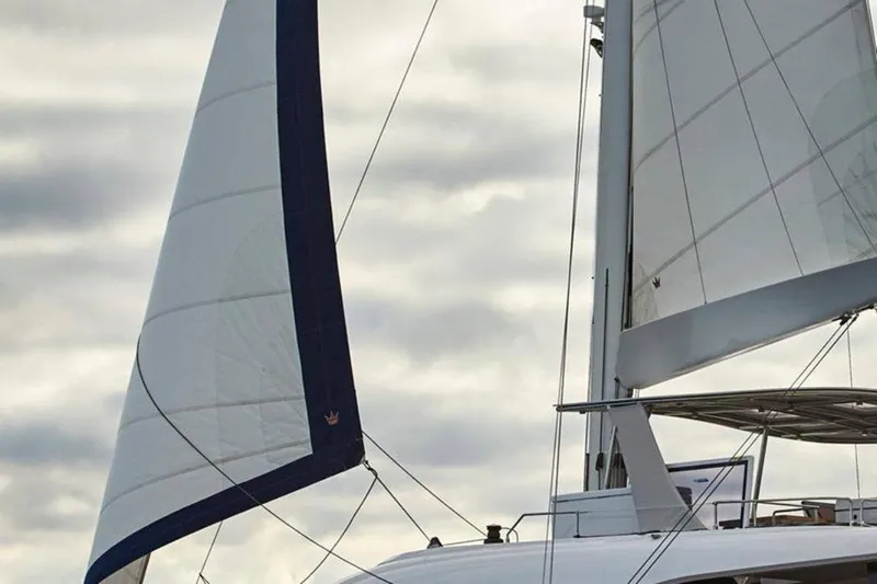  Yacht Photos Pics Sailing yacht Sunreef 60, 2021 model, with sails against cloudy sky.