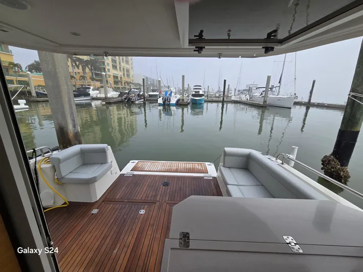 Latitude Adjustment Yacht Photos Pics 2022 Greenline 39 Hybrid yacht interior with wooden deck and marina view.
