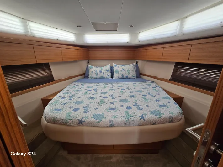 Latitude Adjustment Yacht Photos Pics Luxurious bedroom interior of 2022 Greenline 39 Hybrid yacht with nautical-themed bedding.