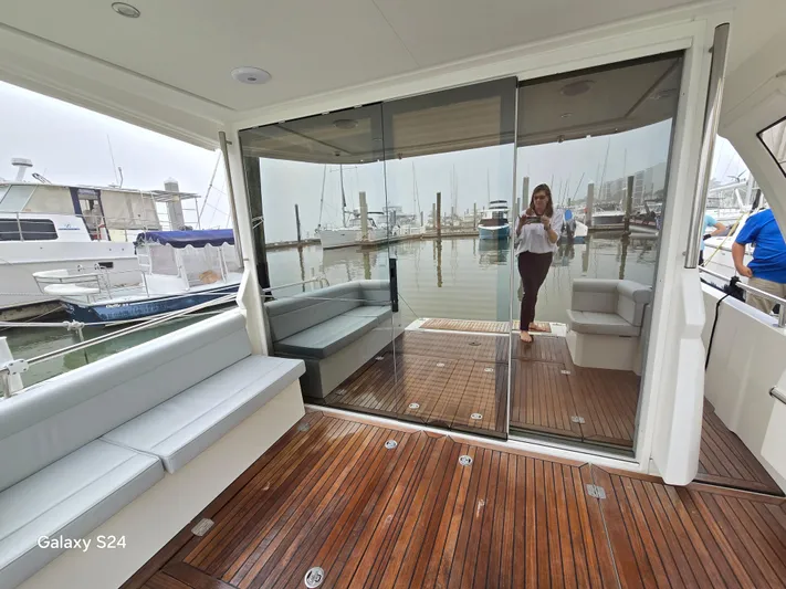 Latitude Adjustment Yacht Photos Pics 2022 Greenline 39 Hybrid yacht interior with wooden deck and marina view.