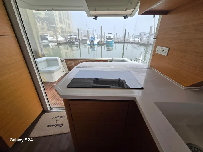 Latitude Adjustment Yacht Photos Pics Interior view of 2022 Greenline 39 Hybrid yacht kitchen with marina backdrop.