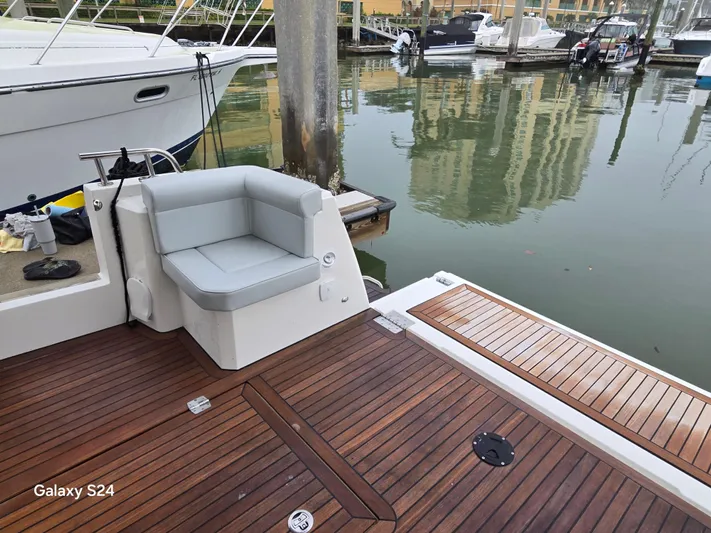 Latitude Adjustment Yacht Photos Pics Luxury yacht deck with cushioned seating, docked in marina. Greenline 39 Hybrid, 2022 model.