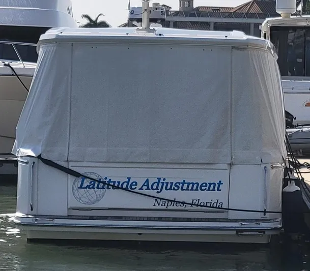 Latitude Adjustment Yacht Photos Pics 2022 Greenline 39 Hybrid boat docked, covered, with "Latitude Adjustment" text, Naples, Florida.