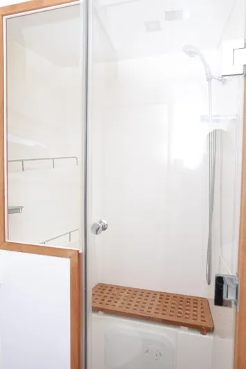  Yacht Photos Pics Shower area in 2023 Aquila 44 Yacht with wooden bench and glass door.