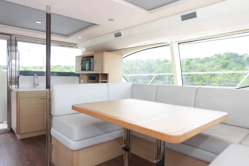  Yacht Photos Pics Interior of 2023 Aquila 44 Yacht with modern dining area and kitchenette.