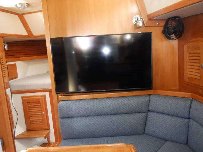 Tapawingo Yacht Photos Pics Interior of 1998 Pacific Seacraft 40 yacht with TV and blue seating.