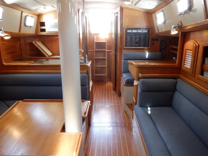 Tapawingo Yacht Photos Pics Interior of 1998 Pacific Seacraft 40 sailboat with wooden finishes and blue seating.