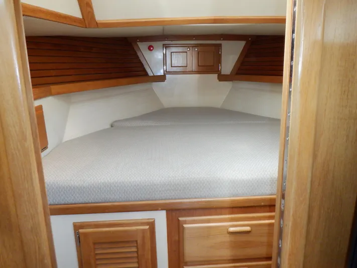 Tapawingo Yacht Photos Pics 1998 Pacific Seacraft 40 interior cabin with wooden finish and cozy bed.