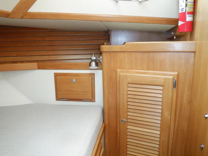 Tapawingo Yacht Photos Pics Interior cabin of 1998 Pacific Seacraft 40 sailboat with wooden cabinetry and bed.