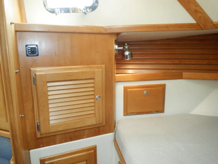 Tapawingo Yacht Photos Pics Interior cabin of 1998 Pacific Seacraft 40 yacht with wooden cabinetry and cozy bed.