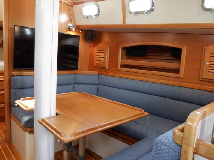 Tapawingo Yacht Photos Pics Interior of 1998 Pacific Seacraft 40 sailboat with cozy seating and wooden table.