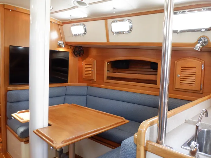 Tapawingo Yacht Photos Pics Interior of 1998 Pacific Seacraft 40 sailboat with cozy seating and wooden table.