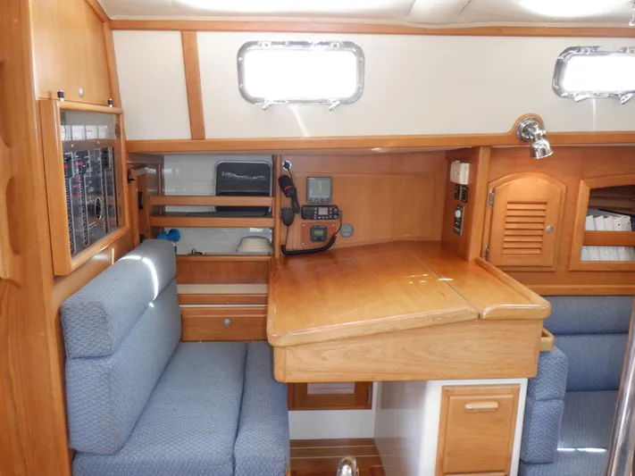 Tapawingo Yacht Photos Pics Interior of 1998 Pacific Seacraft 40 sailboat with wooden cabinetry and blue seating.