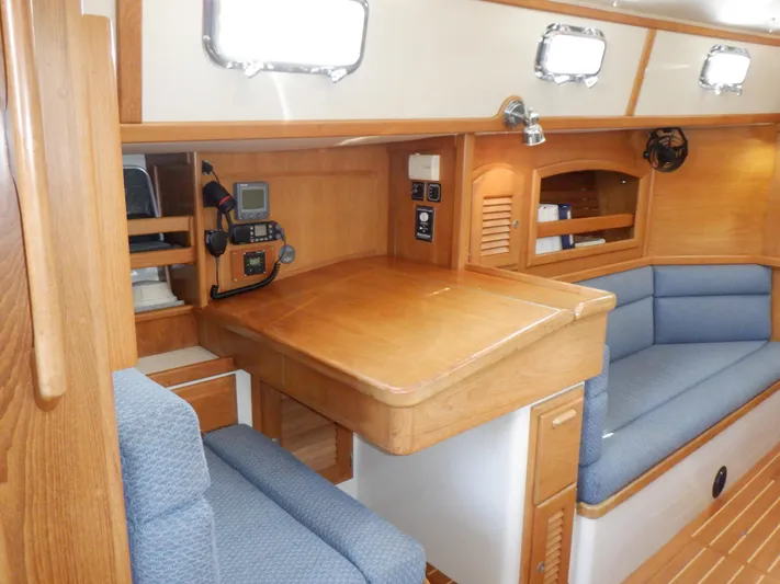 Tapawingo Yacht Photos Pics Interior of 1998 Pacific Seacraft 40 sailboat with wooden cabinetry and blue seating.