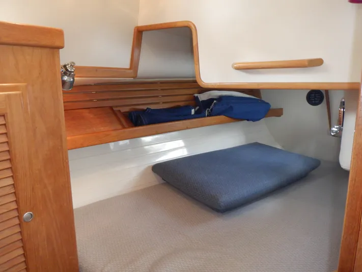 Tapawingo Yacht Photos Pics 1998 Pacific Seacraft 40 interior cabin with wooden shelves and cozy bedding.