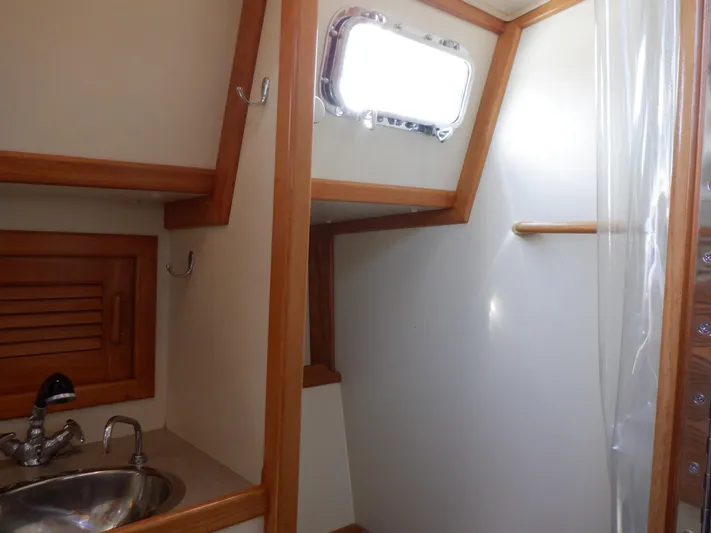 Tapawingo Yacht Photos Pics Interior of 1998 Pacific Seacraft 40 sailboat, featuring a compact bathroom with sink and window.