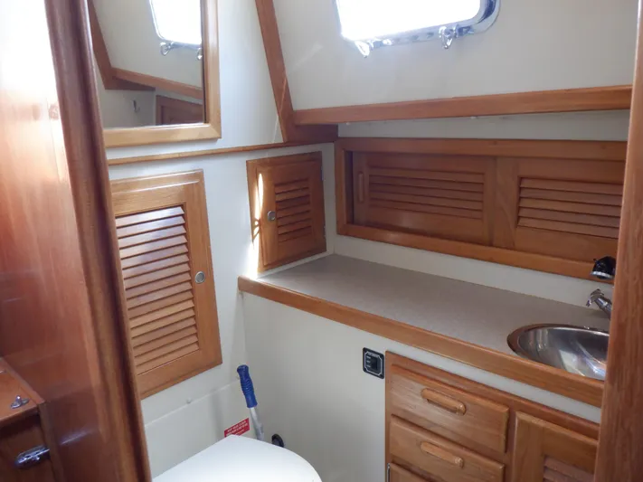 Tapawingo Yacht Photos Pics 1998 Pacific Seacraft 40 yacht bathroom with wooden cabinets and stainless steel sink.