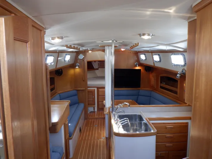 Tapawingo Yacht Photos Pics Interior of 1998 Pacific Seacraft 40 yacht with wood finish and blue seating.