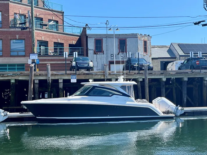 Tinkers Toye Yacht Photos Pics 2024 Tiara Yachts 34 LX docked at a marina with waterfront buildings.
