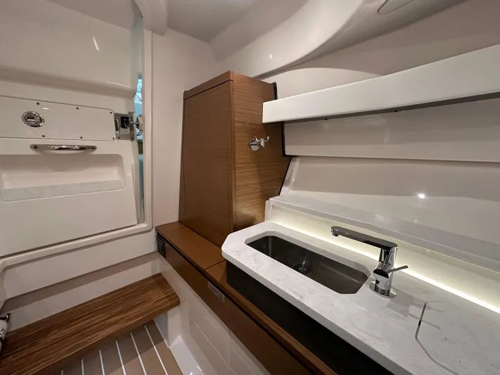 Tinkers Toye Yacht Photos Pics 2024 Tiara Yachts 34 LX interior with modern sink and wooden accents.