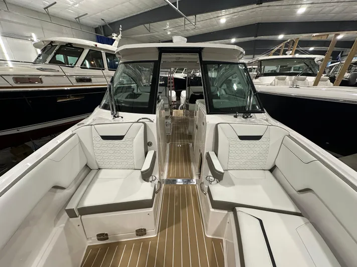 Tinkers Toye Yacht Photos Pics 2024 Tiara Yachts 34 LX interior with luxurious seating and sleek design in a showroom.
