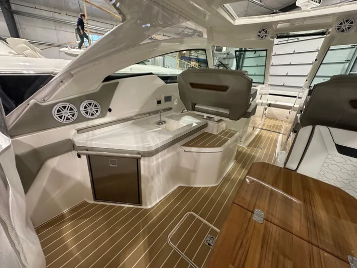 Tinkers Toye Yacht Photos Pics 2024 Tiara Yachts 34 LX interior with sleek design, featuring a kitchenette and seating area.