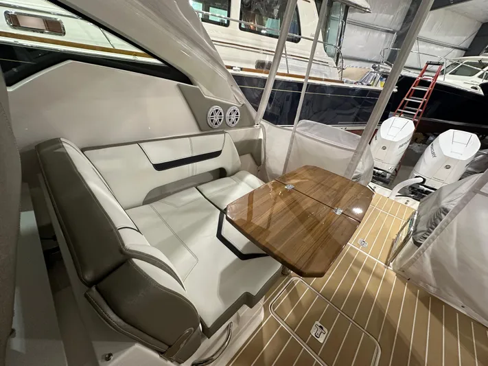 Tinkers Toye Yacht Photos Pics 2024 Tiara Yachts 34 LX interior with seating and wooden table in a boat showroom.