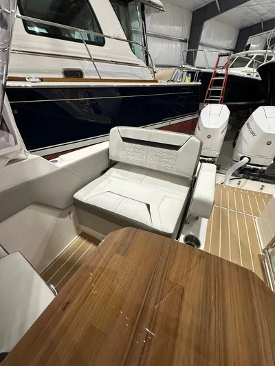 Tinkers Toye Yacht Photos Pics 2024 Tiara Yachts 34 LX interior with seating and wooden table in a showroom.