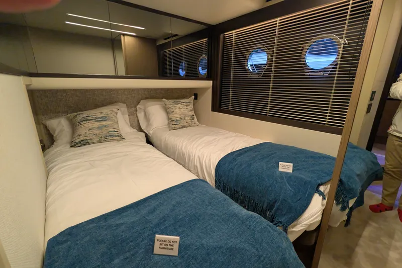  Yacht Photos Pics Luxurious twin bedroom on 2025 Absolute 52 FLY yacht with porthole windows and blue accents.