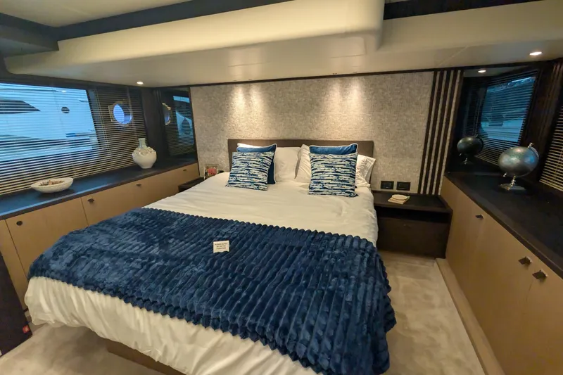  Yacht Photos Pics Luxurious bedroom interior of 2025 Absolute 52 FLY yacht with elegant decor and blue accents.