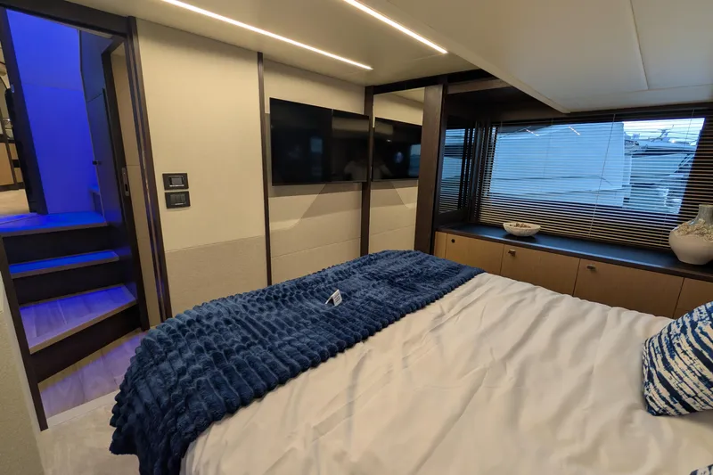  Yacht Photos Pics Luxurious bedroom interior of 2025 Absolute 52 FLY yacht with modern decor and blue accents.