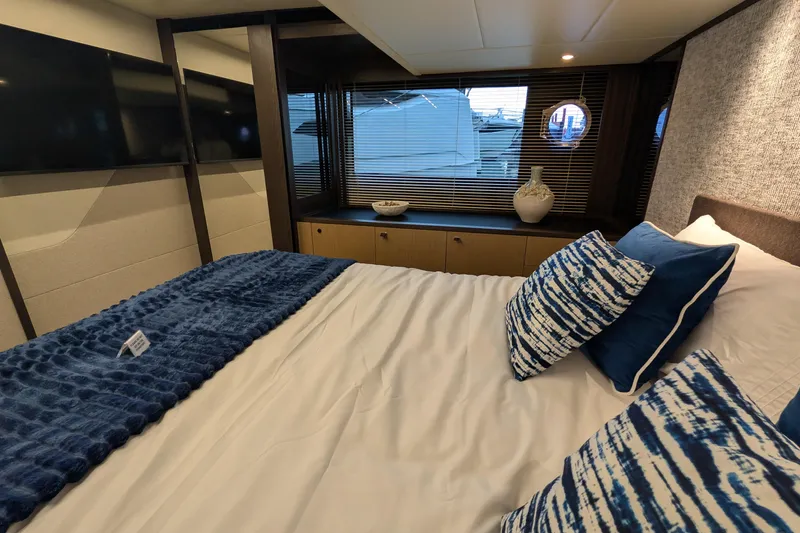 Yacht Photos Pics Luxurious bedroom interior of 2025 Absolute 52 FLY yacht with blue accents and modern decor.