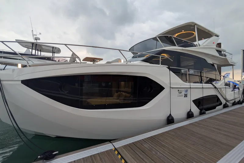  Yacht Photos Pics Luxury 2025 Absolute 52 FLY yacht docked at marina under cloudy sky.
