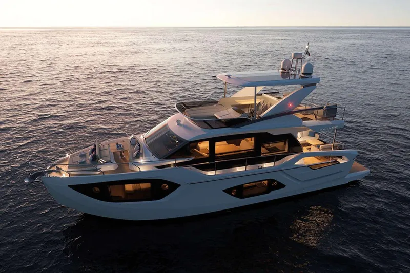  Yacht Photos Pics Luxurious 2025 Absolute 52 FLY yacht cruising at sunset on calm ocean waters.