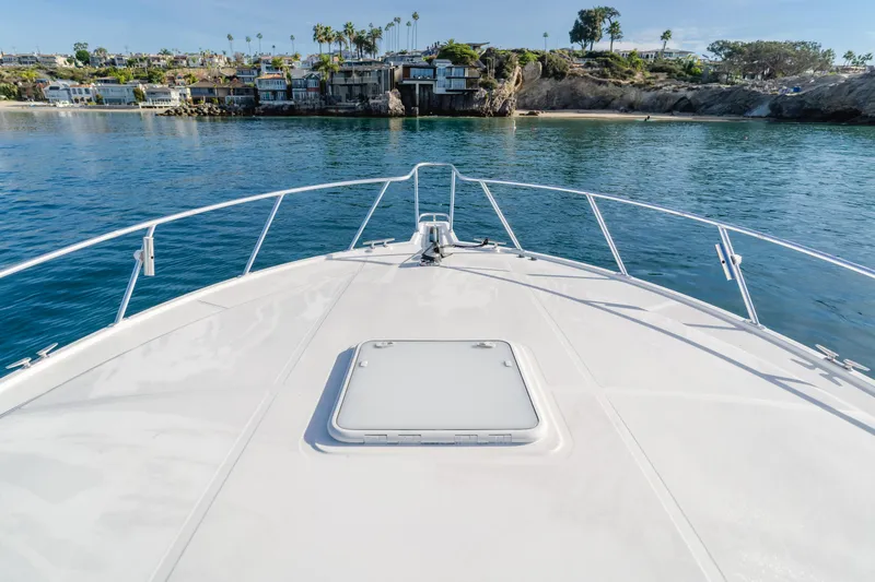 Apothecary Yacht Photos Pics Bow view of 2011 Cabo Express boat approaching scenic coastal homes.