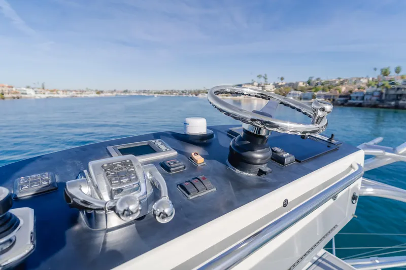 Apothecary Yacht Photos Pics 2011 Cabo Express boat helm with steering wheel and controls, overlooking calm blue waters.