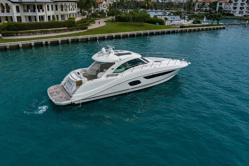 Majestic Stars Yacht Photos Pics 2012 Sea Ray Sundancer 580 yacht cruising in clear blue waters near a marina.