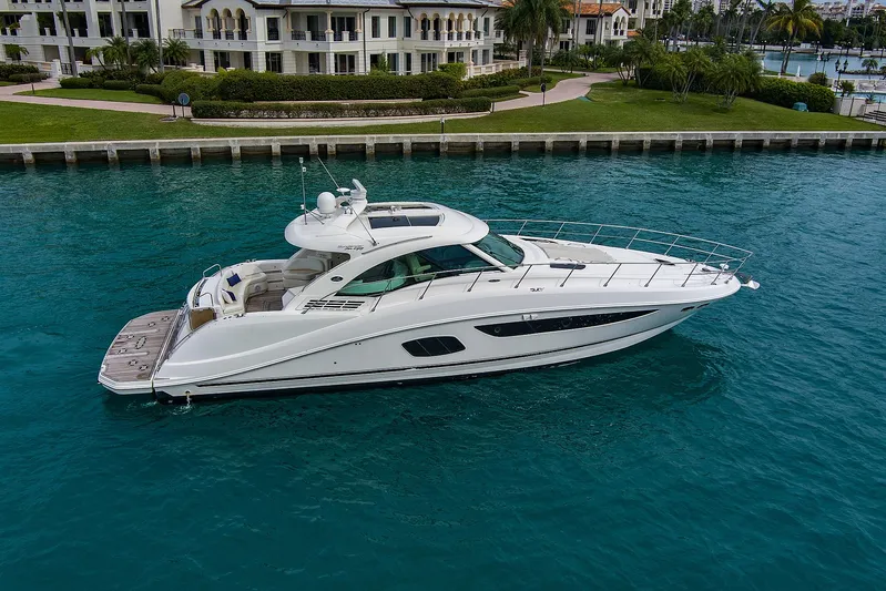 Majestic Stars Yacht Photos Pics 2012 Sea Ray Sundancer 580 yacht cruising in clear blue water near luxury waterfront homes.