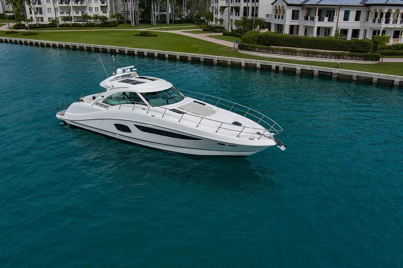 Majestic Stars Yacht Photos Pics 2012 Sea Ray Sundancer 580 yacht cruising in clear blue water near luxury waterfront homes.