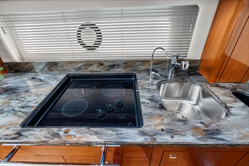 Majestic Stars Yacht Photos Pics Luxurious 2012 Sea Ray Sundancer 580 yacht kitchen with sleek countertop, stove, and sink.