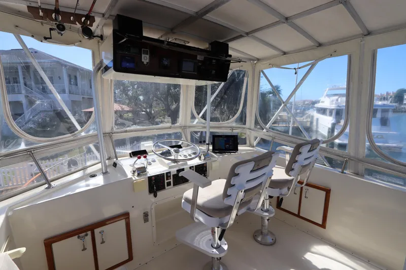 Sea Breeze Yacht Photos Pics Interior helm of 1985 Hatteras 43 Motor Yacht with dual seats and navigation equipment.