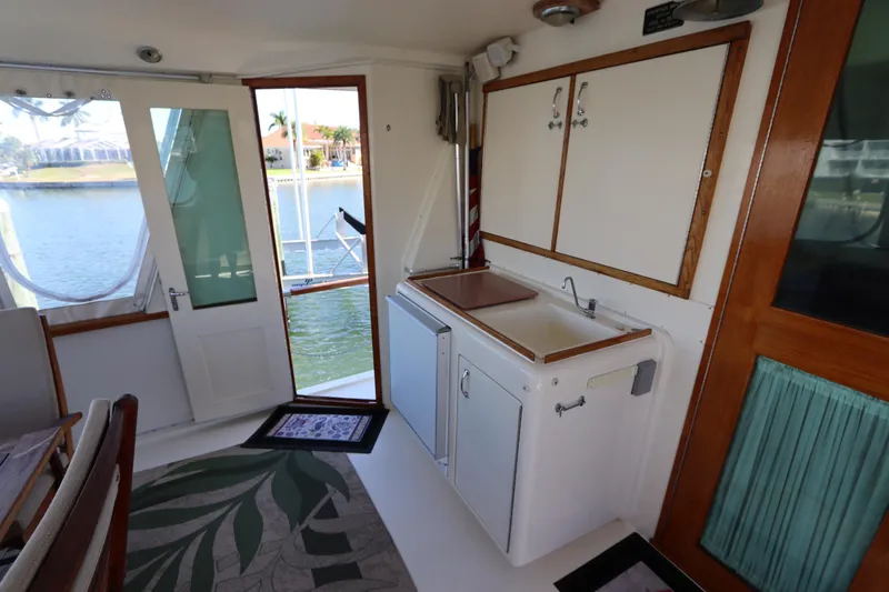 Sea Breeze Yacht Photos Pics 1985 Hatteras 43 Motor Yacht interior with sink, cabinets, and outdoor view.