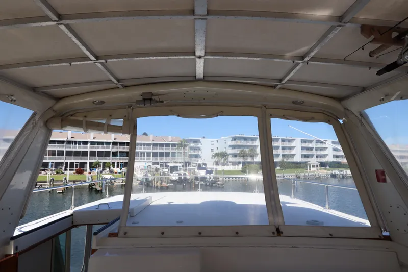 Sea Breeze Yacht Photos Pics Interior view from a 1985 Hatteras 43 Motor Yacht overlooking a marina with waterfront buildings.